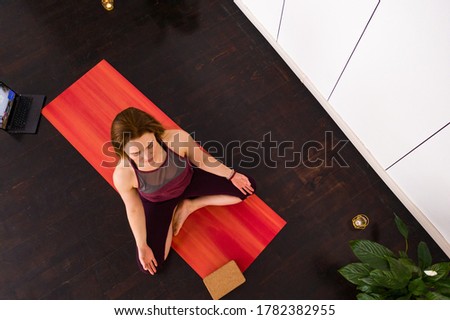 Top view of beautiful young fitness woman working out on wooden floor, doing yoga exercise, full length