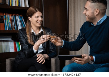 The couple, celebrating with a drink in the law office, after signing a contract