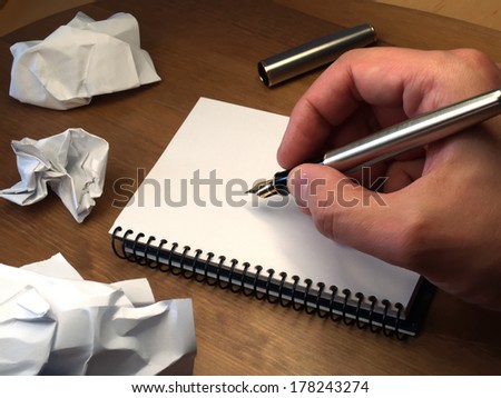 hand writing with foutain pen over white notebook