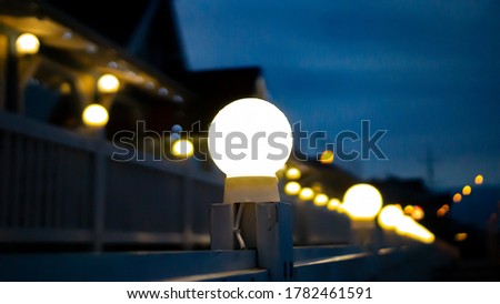 Yellow light bulb glowing in the dark background 