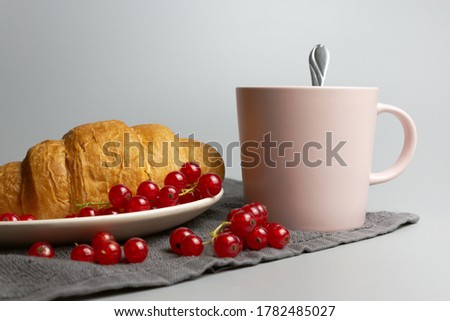Сroissant with coffee breakfast. Currant berries. Fresh bakery. Pink cup of tea. Light grey background. Good morning image. Food photo. Sweet healthy snack and drink. Cafe menu. Americano with pastry.