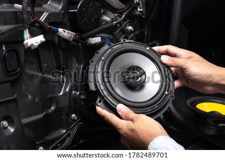 Technician installing the car speaker to the car door. Car audio installation concept. Royalty-Free Stock Photo #1782489701