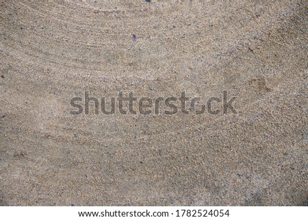 Brush marks on sand surface. Clay court texture. Grainy sand with tier marks. Grey brown asphalt with dust. Grit texture detailed backdrop for rustic design template. Abstract grungy background