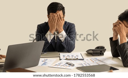 The young business man turned his head off and looked for a solution and on the table full of graphs and computers.