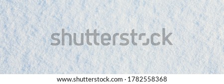 Natural snow texture. Smooth surface of clean fresh snow. Snowy ground. Winter background with snow patterns. Closeup top view. Wide panoramic texture for background and design. Royalty-Free Stock Photo #1782558368