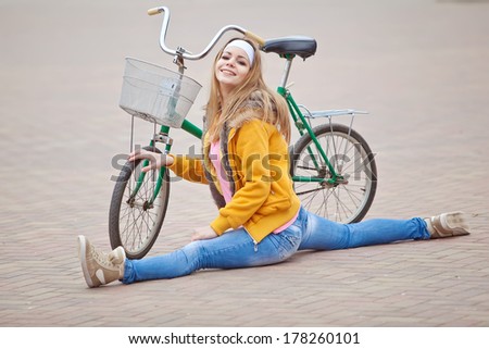 beautiful smiling girl sitting next to bike