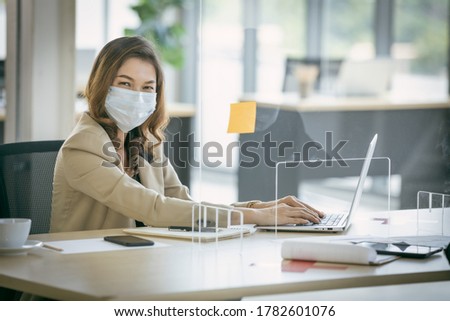 Business office working at new normal social distance office with table shiled partition reduce infection of coronavirus covid-19 pandemic. Office new normal lifestyle.	