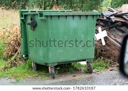 green trash bins near houses
