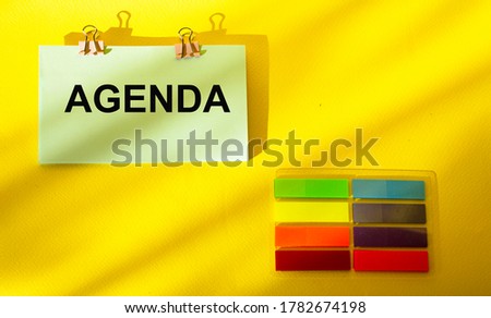 On a yellow background text Agenda, next to it are colored stickers