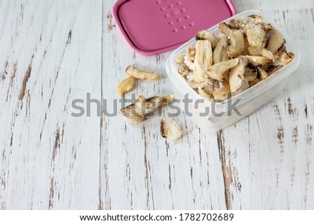 Food for the winter. Frozen vegetables. Container with frozen mushrooms. Copy space.