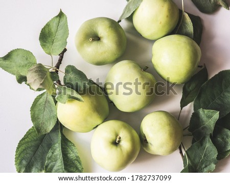 Composition of green apples and leaves on a white background. Wallpaper of fruits.Top view, flat lay.