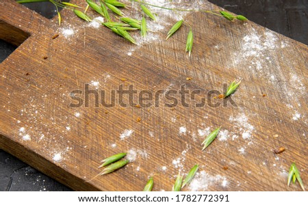 Kitchen cutting Board, which is scattered with flour, bread crumbs and rye grains.