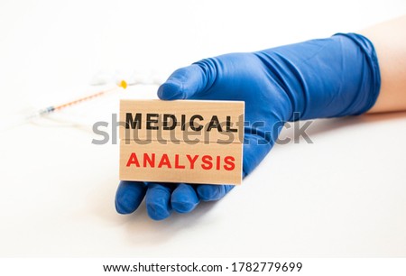 Hands in medical protective gloves hold wooden cubes with the inscription. Medical concept