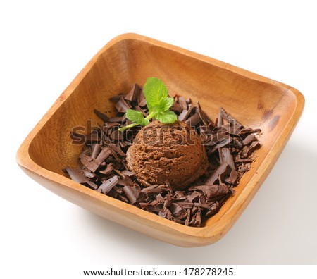 Scoop of ice cream and chocolate shavings in wooden bowl
