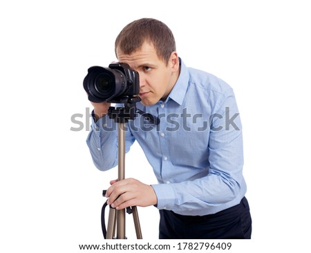 male photographer or videographer taking photo or shooting video with modern dslr camera on tripod isolated on white background