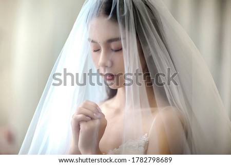 Praying asian bride with veil