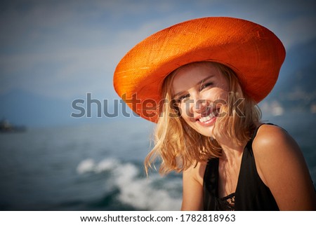 Stunning female model photographed on a wooden speed boat touring Lake Como Italy 