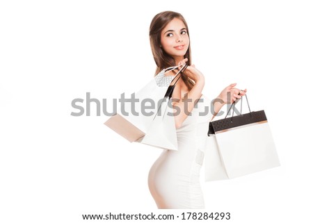 Gorgeous fashionable young brunette woman in a dress with shopping bags.