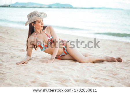 Beautiful of smiling woman in bikini Lying on Beach, summer vacation.Leisure activities