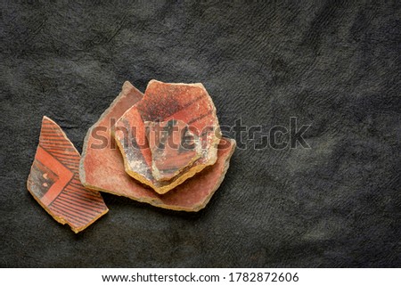 ancient Native American Indian (Anasazi) artifacts, several pottery fragments  on a dark paper background with a copy space