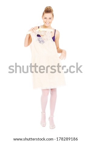 A picture of a happy woman trying on a white dress
