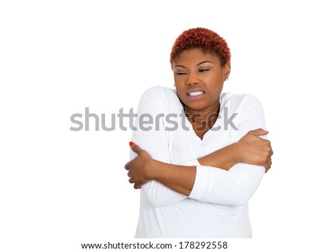Closeup portrait of young pretty beautiful woman, employee worker freezing, hugging holding herself to make warm, isolated on white background. Negative emotion facial expression feeling. Arctic chill