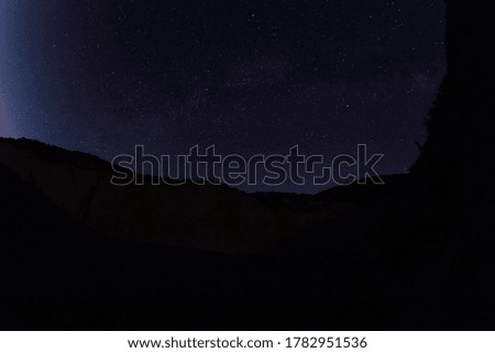 Night star sky with Milky way galaxy and canyon, mountains with trees