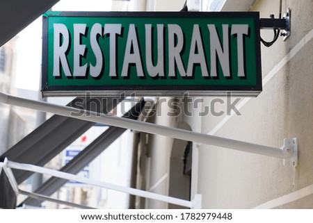 restaurant text sign green on french building city street 