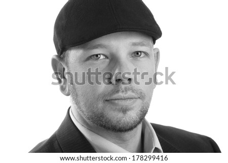 Portrait Of A Young Man - This is a high contrast black and white photo of a young man wearing a hat and jacket. Shot on an isolated white background and processed slightly to enhance detail.