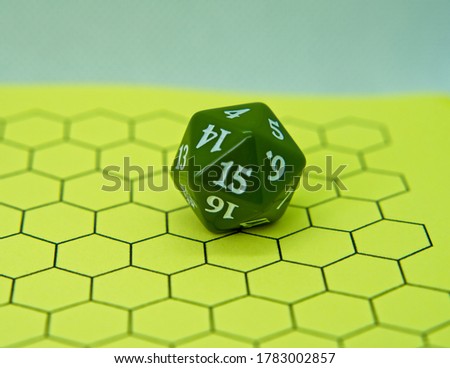 Role-playing board with green dice on top in a pentagonal shape