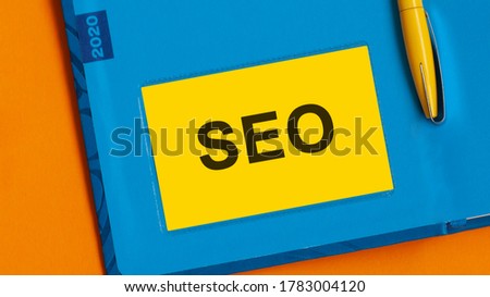 Notebook with text inside SEO on yellow page with pensil