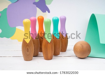 Skittles and a ball made of natural material. Bowling for children made of wood. Set for bowling. Children's wooden toys.