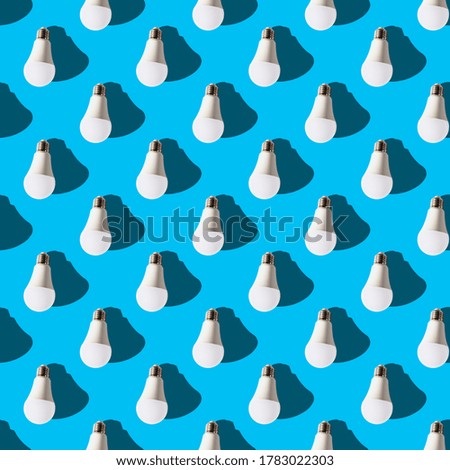 seamless pattern. white lightbulbs is down on light blue background