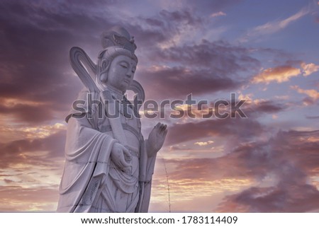 scenic sky weather with Chinese deity statue in the foreground.