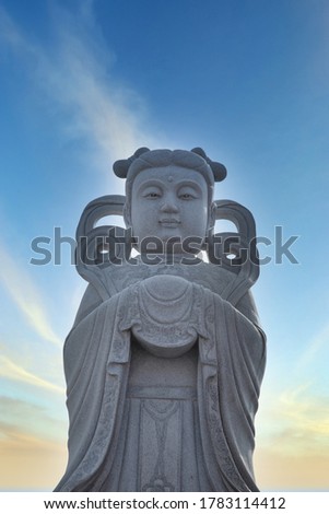 scenic sky weather with Chinese deity statue in the foreground.