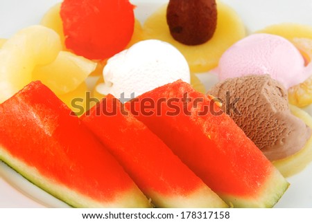 watermelon plum and slice of pineapple and chocolate and fruit ice cream on white plate isolated over white background