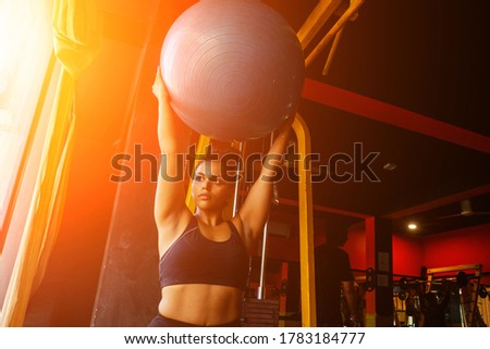 indian woman doing pilates and balance exercises gymnastic ball