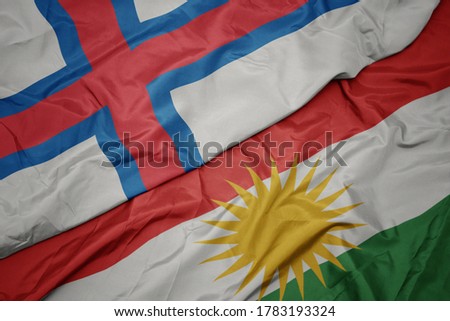 waving colorful flag of kurdistan and national flag of faroe islands. macro