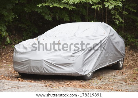A car parked with a a protective cover. Royalty-Free Stock Photo #178319891