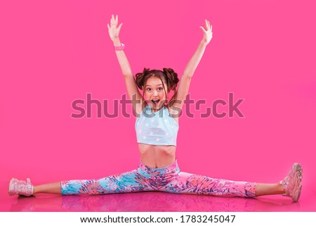 happy sporty girl making fitness training. looking straight. isolated on  pink background. copy space