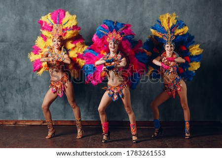 Three Woman dancing in brazilian samba carnival costume with colorful feathers plumage. Royalty-Free Stock Photo #1783261553