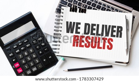 Keyboard of laptop, calcualtor, pencil and notepad with text WE DELIVER RESULTS on the white background