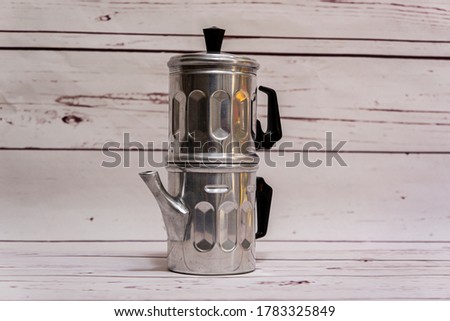 Traditional old Italian Neapolitan coffee maker or flip pot for brewing coffee with boiling water with dents in the metal Royalty-Free Stock Photo #1783325849
