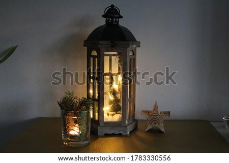 Christmas lamp decorated with many lights and tealight candle

