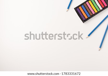 Colorful wax crayons and pencils isolated on white background. Copy space. Top view.