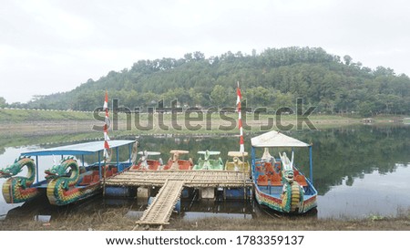 The dragon-shaped boat sails over the clear, wide lake water and is used for tourism needs. Travel photos. Suitable for people looking for photos about tourist destinations.