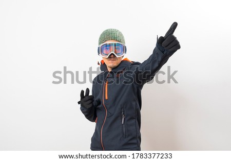 Asian man in a ski outfit ,gloves and goggles over white background.