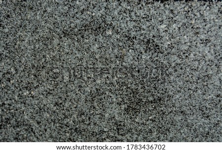 a porous texture consisting of small stones of gray white and black color of different sizes. blurred focus