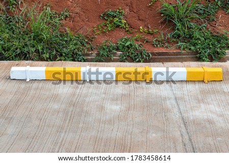 Wheel stop concrete with paint yellow and white of outdoor parking, Rubber Wheel Stopper/Parking space. yellow sign on the road of parking car
