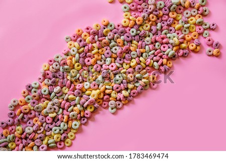 Colorful cereal loops on pink background
